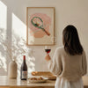 Woman holding a glass of red wine in a cozy room with a painting on the wall.