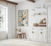 Modern kitchen interior with white cabinetry, decorative painting, and wooden accents.