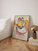 Cowgirl hat painting in a wooden frame on a wall next to a white sofa and gold lamp.